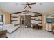 Vaulted-ceiling living room with barn wood accent wall, white sofa, sliding glass doors, and tile flooring at 1 Sportsman Cir, Rotonda West, FL 33947