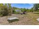 View of the backyard with a seating arrangement, fire pit, and mature trees at 10133 Gulfstream Blvd, Englewood, FL 34224