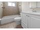 Cozy bathroom featuring a bathtub, tiled walls, a white vanity, and mirror, creating a clean and refreshing space at 10133 Gulfstream Blvd, Englewood, FL 34224