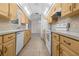 Efficient kitchen with wooden cabinetry, white appliances, and practical layout, ideal for easy meal preparation and storage at 10133 Gulfstream Blvd, Englewood, FL 34224