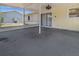 View of the covered patio area with a ceiling fan, and sliding glass door entrance to home at 10133 Gulfstream Blvd, Englewood, FL 34224