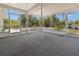 A screened porch features an overhead ceiling fan and overlooks a backyard with mature trees at 10133 Gulfstream Blvd, Englewood, FL 34224