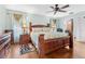 Bright main bedroom features a large bed, ceiling fan, and dark wood furnishings at 1041 S Salford Blvd, North Port, FL 34287