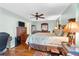 Comfortable bedroom featuring hardwood floors, a ceiling fan, and a well-lit desk area at 1041 S Salford Blvd, North Port, FL 34287