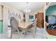 Elegant dining room featuring a classic chandelier, decorative wallpaper, and tiled flooring at 1041 S Salford Blvd, North Port, FL 34287