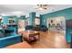 Bright open living room with beautiful teal walls, hardwood floors, and chandelier lighting at 1041 S Salford Blvd, North Port, FL 34287