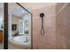 Luxurious bathroom with soaking tub, columns, decorative window, and a tiled shower with a handheld showerhead at 1062 Eagles Flight Way, North Port, FL 34287