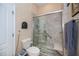 Bathroom featuring tiled shower with glass door, bench seat, grab bar and handheld shower at 1062 Eagles Flight Way, North Port, FL 34287