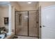 Walk-in shower features elegant tile, built in seat, and glass doors in primary bathroom suite at 1062 Eagles Flight Way, North Port, FL 34287