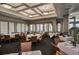 Elegant dining room with tables set for dining in a room with large windows at 1062 Eagles Flight Way, North Port, FL 34287