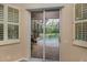 Sliding glass doors lead to the pool with screened-in lanai and lush greenery at 1062 Eagles Flight Way, North Port, FL 34287