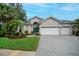 Charming single-story home with a well-manicured lawn, a three-car garage, and a beautiful teal-colored front door at 1062 Eagles Flight Way, North Port, FL 34287