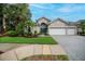 Home exterior with manicured lawn, paver driveway, and a bright blue door at 1062 Eagles Flight Way, North Port, FL 34287