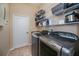 Well-organized laundry room with modern washer and dryer, ample shelving, and white door at 1062 Eagles Flight Way, North Port, FL 34287