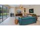 Inviting living room with a comfortable teal sofa, stylish décor, and views of the backyard pool area at 1062 Eagles Flight Way, North Port, FL 34287