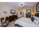 Bedroom with ceiling fan features an en suite bathroom and a wall mounted television at 1062 Eagles Flight Way, North Port, FL 34287