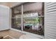 View of a screened-in pool and patio area from an adjacent room with plantation shutters at 1062 Eagles Flight Way, North Port, FL 34287