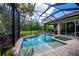 Screened-in pool and spa area with lush landscaping and room for entertaining at 1062 Eagles Flight Way, North Port, FL 34287