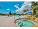 Community pool and spa area with lounge chairs, tables, and lush landscaping at 1062 Eagles Flight Way, North Port, FL 34287