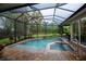 Screened in pool with attached spa and view of the manicured backyard at 1062 Eagles Flight Way, North Port, FL 34287