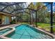 Inviting screened-in pool and spa with lush landscape for privacy and relaxation at 1062 Eagles Flight Way, North Port, FL 34287