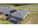 An aerial view displays a house with a screened pool, set amidst a serene backdrop of trees and a pond at 11088 Pinot Dr, Venice, FL 34293