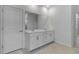 Bright bathroom featuring double vanity with white cabinetry, a large mirror, and stylish flooring at 11088 Pinot Dr, Venice, FL 34293