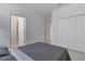 Bright bedroom featuring neutral walls, a cozy grey comforter, and a large double door closet at 11088 Pinot Dr, Venice, FL 34293