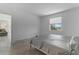 Clean bedroom shows bed, neutral tile flooring, window with a backyard view, and an open doorway at 11088 Pinot Dr, Venice, FL 34293