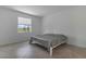 Simple bedroom with tile flooring, one window with blinds, and a bed with grey bedding at 11088 Pinot Dr, Venice, FL 34293