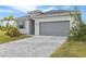A well-manicured lawn and a stone driveway lead up to the garage of this single Gathering home at 11088 Pinot Dr, Venice, FL 34293