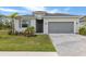 Charming one-story home featuring gray exterior paint, a paved driveway, and a two-car garage at 11088 Pinot Dr, Venice, FL 34293