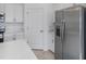 Close-up of modern kitchen with white cabinets, quartz countertops, and stainless steel refrigerator at 11088 Pinot Dr, Venice, FL 34293