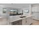 Stylish kitchen with stainless steel appliances, island, and view to the living room and outdoor patio at 11088 Pinot Dr, Venice, FL 34293