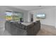 Spacious living room with comfortable sectional sofa, outdoor views and a mounted TV for relaxation at 11088 Pinot Dr, Venice, FL 34293