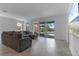 Bright living room featuring a large sectional sofa, tile floors, and sliding glass doors to the pool at 11088 Pinot Dr, Venice, FL 34293