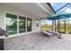 Covered patio with lounge chairs, umbrella, and a view of the pool and lush greenery beyond at 11088 Pinot Dr, Venice, FL 34293