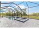 Screened pool and spa with blue-tiled accents offer a relaxing outdoor experience with scenic views at 11088 Pinot Dr, Venice, FL 34293