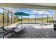 Screened-in pool and spa area with outdoor seating, umbrella, and views of the surrounding landscape at 11088 Pinot Dr, Venice, FL 34293