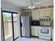 Bright kitchen featuring stainless steel appliances, white cabinetry, and a sliding glass door at 13100 S Mccall Rd # 125, Port Charlotte, FL 33981