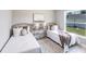 Bright bedroom with two twin beds, neutral decor, and a large window offering natural light at 14130 Massey Ave, Port Charlotte, FL 33953