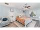 A cozy bedroom with a ceiling fan, light blue walls, a soft rug, and a queen bed at 1444 Frisco Ter, Port Charlotte, FL 33953