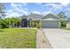 Charming single-story home with a well-manicured lawn and an attached two-car garage at 1444 Frisco Ter, Port Charlotte, FL 33953