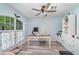 A well-lit home office featuring a desk, a rolling chair, light hardwood floors, and a large window at 1444 Frisco Ter, Port Charlotte, FL 33953