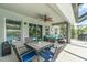 Covered outdoor patio area featuring a dining table, ceiling fan, and comfortable seating area at 1444 Frisco Ter, Port Charlotte, FL 33953