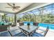 Screened-in patio with a ceiling fan overlooks a sparkling pool and a built-in hot tub at 1444 Frisco Ter, Port Charlotte, FL 33953