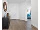 Bright entryway featuring wood floors, a decorative mirror, and an antique-style cabinet with access to the main bedroom at 15069 Anchorage Rd, Punta Gorda, FL 33982