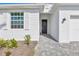 Close up of the home's exterior showcasing the front door, window, and a beautifully landscaped front yard at 15069 Anchorage Rd, Punta Gorda, FL 33982
