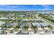 This aerial view showcases a neighborhood with modern homes, lush landscaping, and a picturesque lake in the distance at 16176 Lotus Way, Punta Gorda, FL 33982