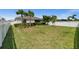 Expansive backyard with lush grass, mature landscaping, and a pristine white fence at 16176 Lotus Way, Punta Gorda, FL 33982